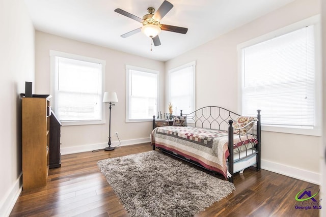 bedroom featuring a ceiling fan, baseboards, and dark wood-style flooring