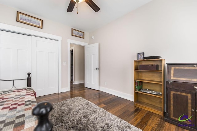 bedroom with a closet, baseboards, dark wood finished floors, and a ceiling fan