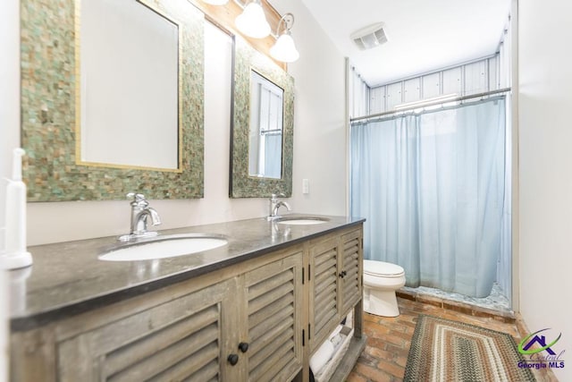 bathroom featuring visible vents, toilet, brick floor, and a sink