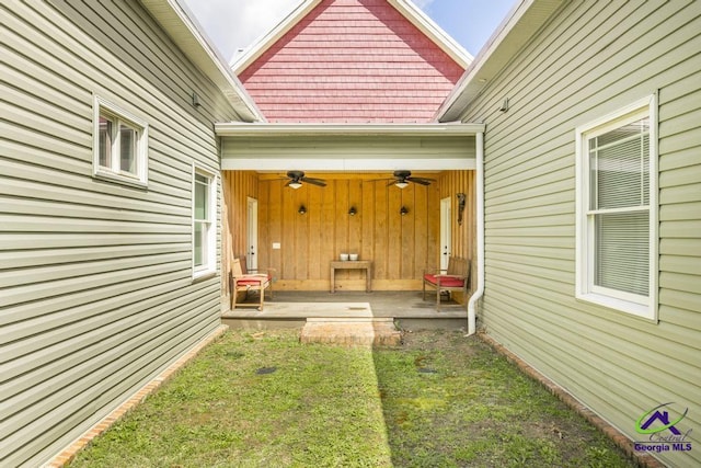 doorway to property with a garage and ceiling fan