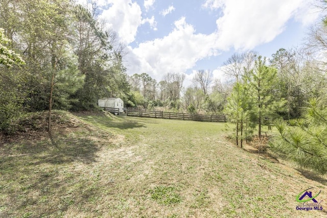 view of yard featuring an outbuilding and fence