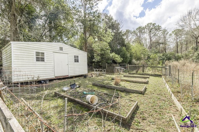 view of yard with fence, an outbuilding, a vegetable garden, and a shed