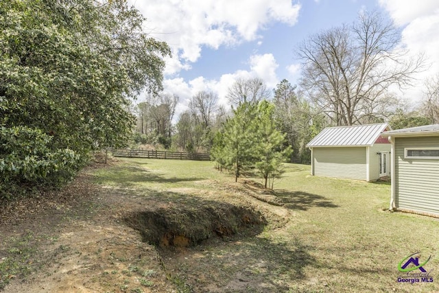 view of yard with an outdoor structure, fence, and a shed