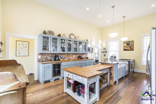 kitchen featuring tasteful backsplash, wooden counters, wine cooler, freestanding refrigerator, and dark wood-style floors