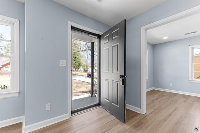 foyer featuring baseboards, visible vents, and light wood-type flooring