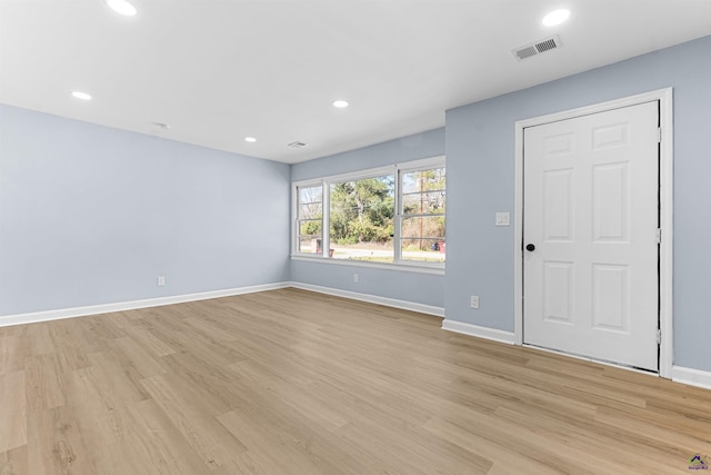 empty room featuring light wood-type flooring, visible vents, baseboards, and recessed lighting