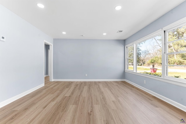 spare room featuring light wood-style flooring, recessed lighting, baseboards, and visible vents