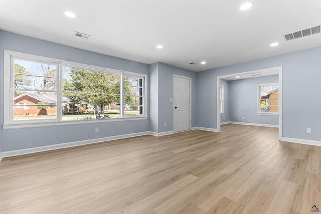 unfurnished living room with a wealth of natural light, visible vents, and recessed lighting