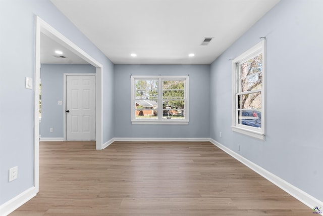 spare room with baseboards, visible vents, and a wealth of natural light