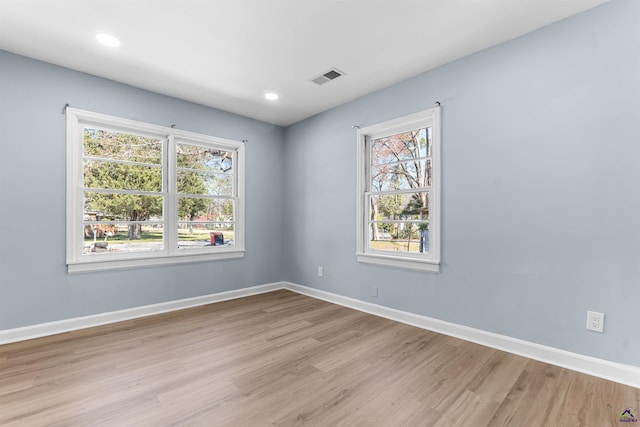 spare room with plenty of natural light, baseboards, and visible vents