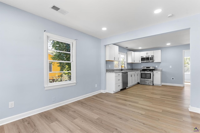 kitchen featuring a wealth of natural light, visible vents, baseboards, and appliances with stainless steel finishes