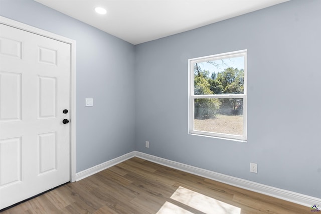 spare room featuring recessed lighting, baseboards, and wood finished floors