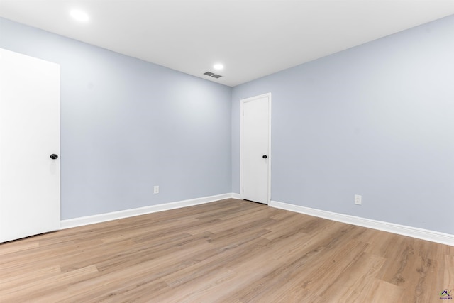 spare room featuring light wood-type flooring, visible vents, baseboards, and recessed lighting