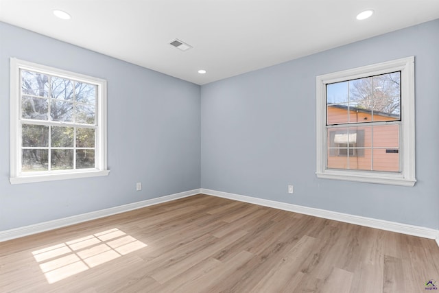 unfurnished room with baseboards, visible vents, and a wealth of natural light