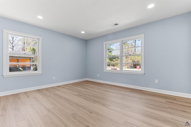 spare room featuring a healthy amount of sunlight, visible vents, and baseboards