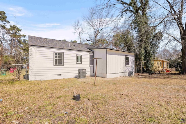 rear view of property featuring crawl space, central AC unit, and a lawn