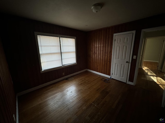 unfurnished bedroom featuring wood finished floors and baseboards