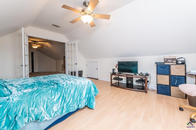 bedroom with visible vents, wood finished floors, baseboards, lofted ceiling, and ceiling fan