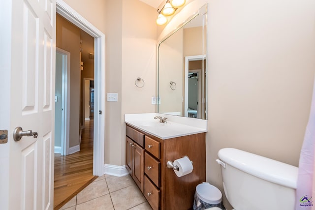 bathroom featuring tile patterned flooring, toilet, vanity, and baseboards