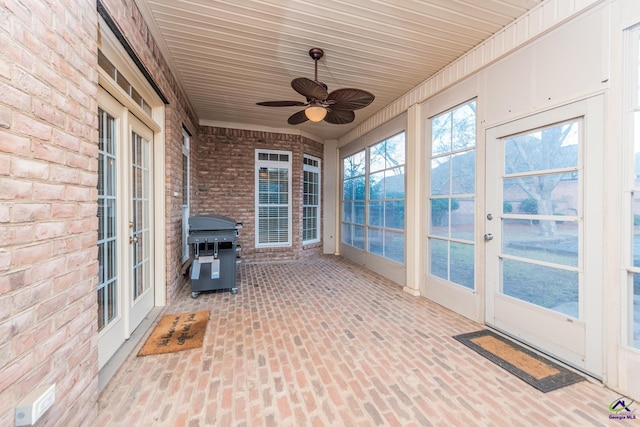 unfurnished sunroom featuring ceiling fan