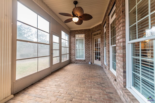 unfurnished sunroom with a ceiling fan