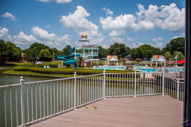 wooden deck with a community pool and a water view