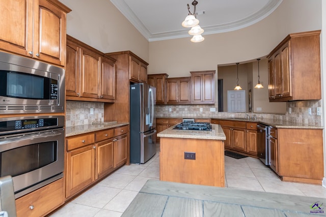 kitchen featuring brown cabinetry, stainless steel appliances, light tile patterned flooring, and crown molding