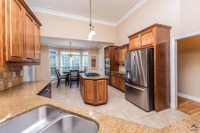 kitchen with an inviting chandelier, ornamental molding, appliances with stainless steel finishes, and pendant lighting