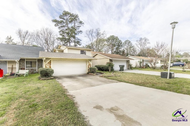 view of front of house with an attached garage, concrete driveway, and a front lawn