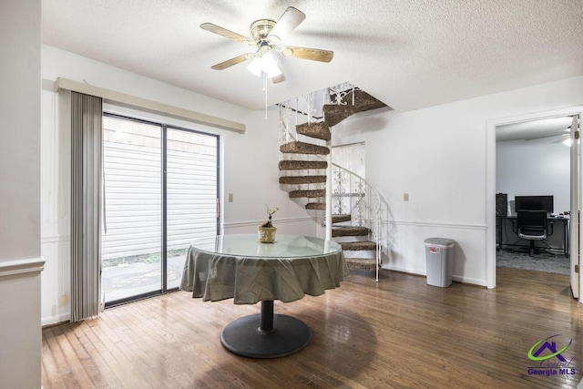 dining area with stairway, plenty of natural light, wood finished floors, and a ceiling fan