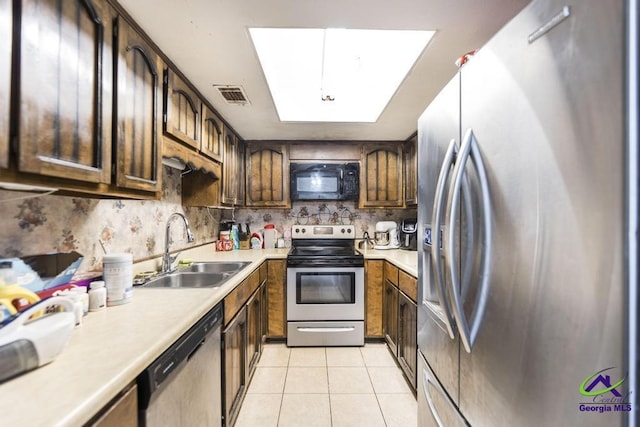 kitchen featuring visible vents, light countertops, light tile patterned floors, appliances with stainless steel finishes, and a sink