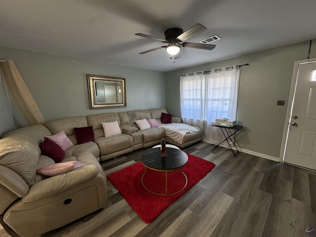 living room featuring visible vents, wood finished floors, baseboards, and ceiling fan