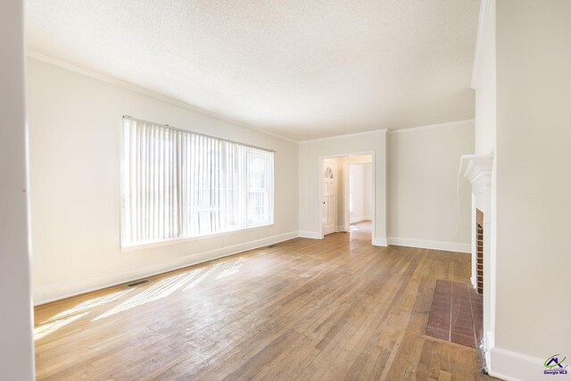 unfurnished living room featuring crown molding, baseboards, wood-type flooring, and a textured ceiling