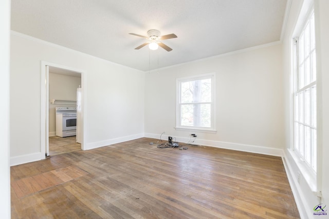 spare room featuring baseboards, wood finished floors, a ceiling fan, and crown molding