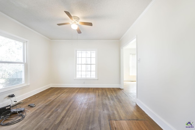 unfurnished room with crown molding, wood finished floors, baseboards, and a textured ceiling