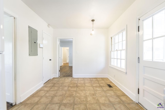 unfurnished dining area featuring electric panel, visible vents, and baseboards