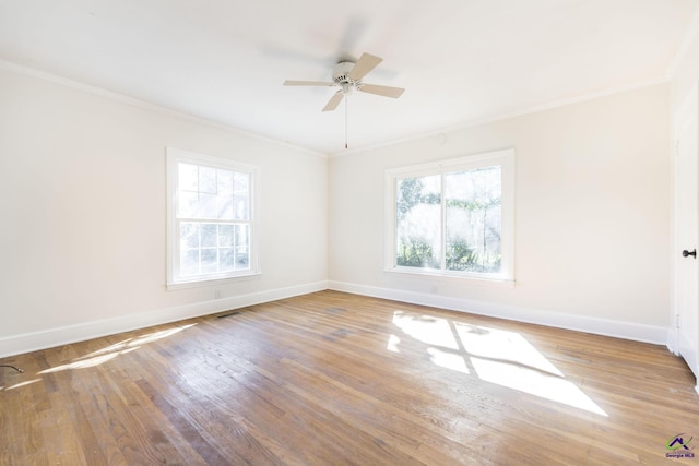 empty room featuring visible vents, wood finished floors, crown molding, baseboards, and ceiling fan