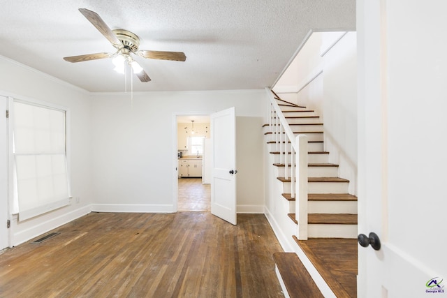 interior space featuring visible vents, ceiling fan, stairway, hardwood / wood-style flooring, and a textured ceiling