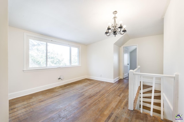 interior space featuring wood finished floors, baseboards, and a chandelier