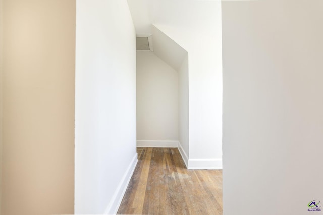 hallway featuring wood finished floors and baseboards