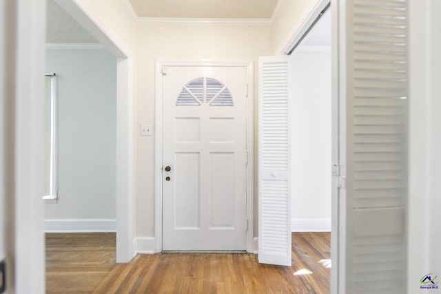 foyer featuring crown molding, wood finished floors, and baseboards