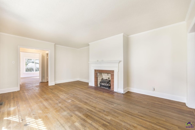 unfurnished living room with baseboards, wood finished floors, and a fireplace