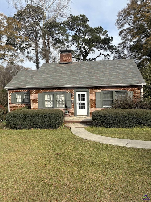 view of front facade with a chimney and a front yard