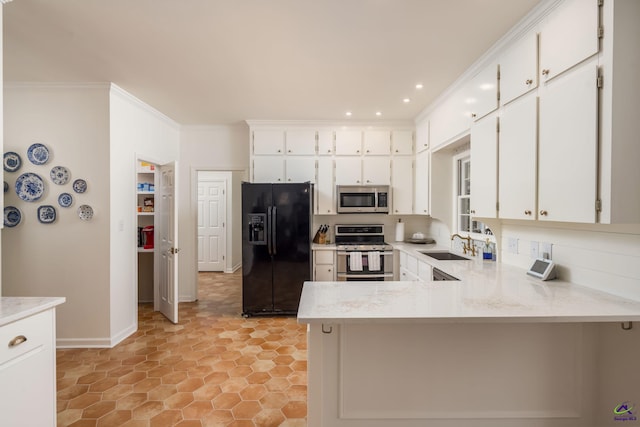 kitchen with ornamental molding, a sink, a peninsula, appliances with stainless steel finishes, and white cabinets