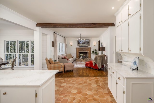 kitchen featuring beam ceiling, white cabinets, an inviting chandelier, and ornamental molding