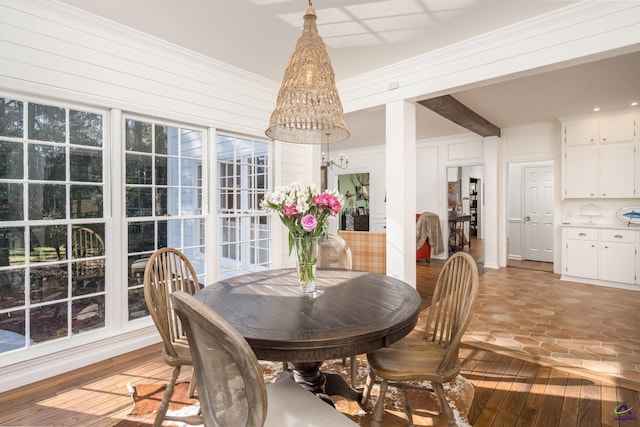 dining room featuring a chandelier, light wood finished floors, and crown molding