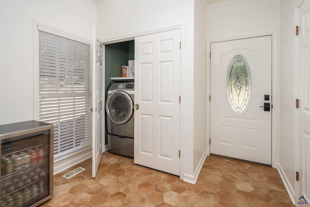 clothes washing area with visible vents, crown molding, baseboards, laundry area, and washer / clothes dryer