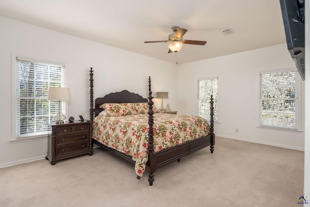 bedroom featuring a ceiling fan, visible vents, light colored carpet, and baseboards