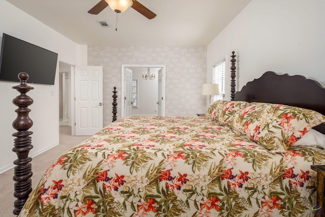 bedroom featuring visible vents, light carpet, ceiling fan with notable chandelier, and wallpapered walls