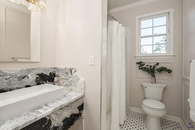 bathroom with a shower with shower curtain, an inviting chandelier, toilet, and crown molding